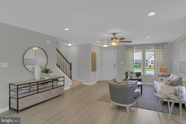 living room featuring light hardwood / wood-style flooring and ceiling fan