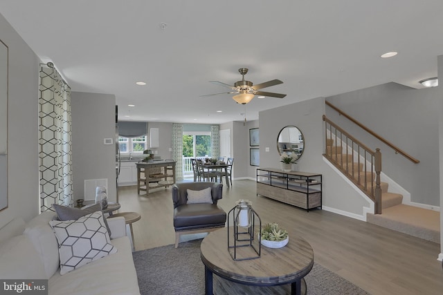 living room with ceiling fan and light hardwood / wood-style flooring