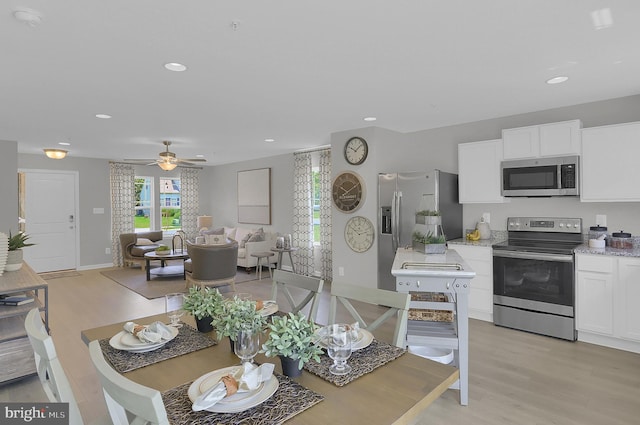 dining area with ceiling fan and light hardwood / wood-style flooring