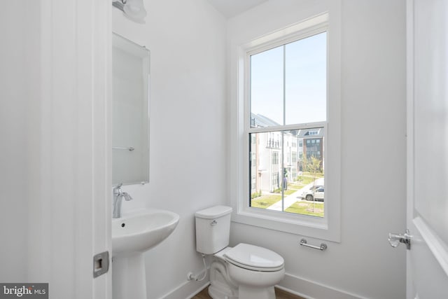 bathroom with a healthy amount of sunlight and toilet