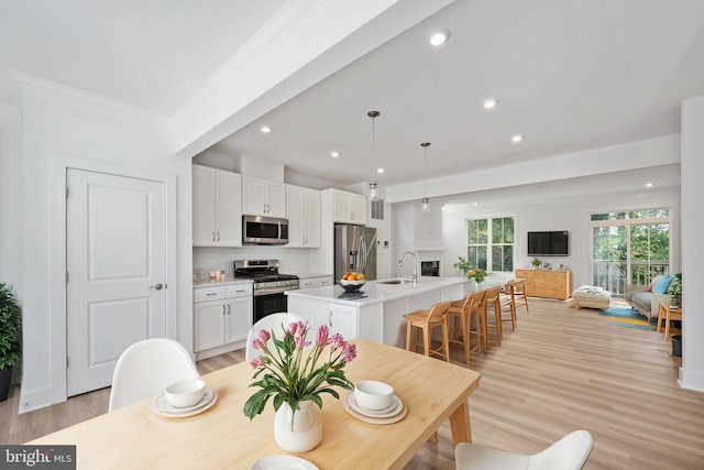 dining area with light hardwood / wood-style floors, crown molding, sink, and beamed ceiling