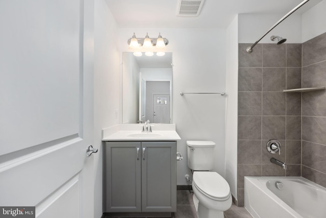 full bathroom featuring tiled shower / bath combo, tile patterned floors, vanity, and toilet