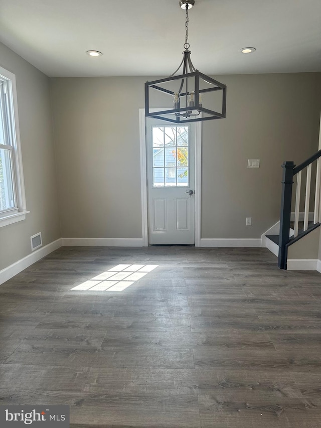 entrance foyer with dark hardwood / wood-style floors and a chandelier