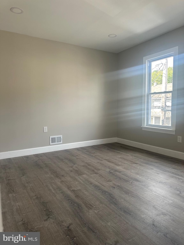 unfurnished room with dark wood-type flooring