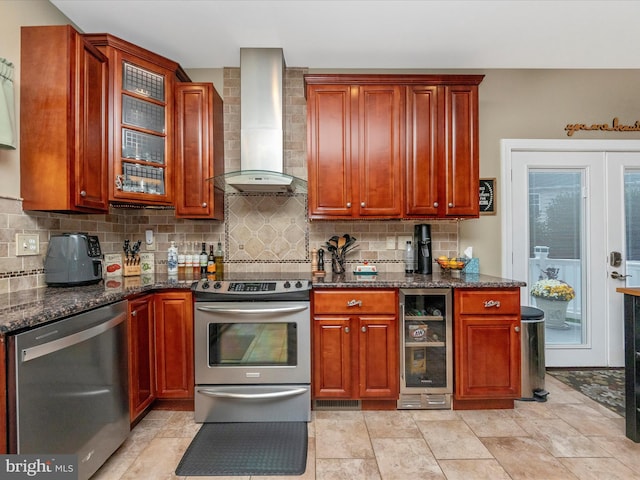 kitchen featuring tasteful backsplash, beverage cooler, wall chimney range hood, appliances with stainless steel finishes, and dark stone counters