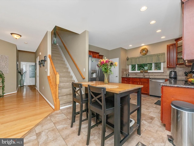 kitchen featuring a center island, tasteful backsplash, wooden counters, light hardwood / wood-style floors, and appliances with stainless steel finishes