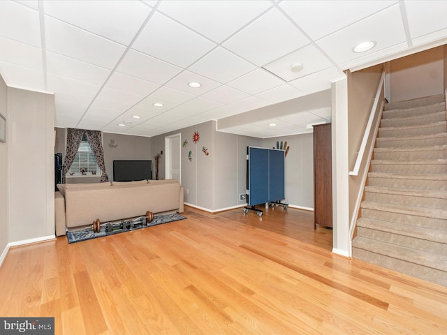 unfurnished living room with wood-type flooring and a drop ceiling