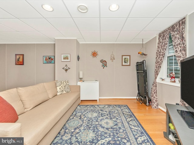 living room with a drop ceiling and hardwood / wood-style floors