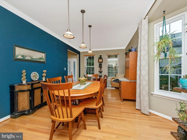 dining space with light hardwood / wood-style flooring and ornamental molding