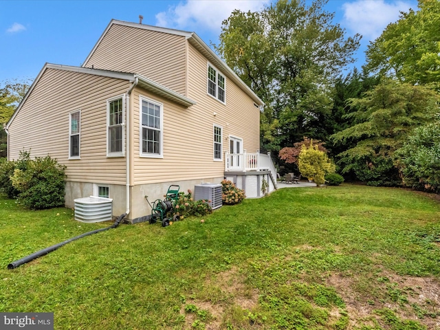 rear view of house with a yard, cooling unit, and a deck