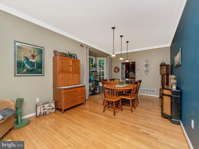 dining space featuring light hardwood / wood-style flooring and ornamental molding