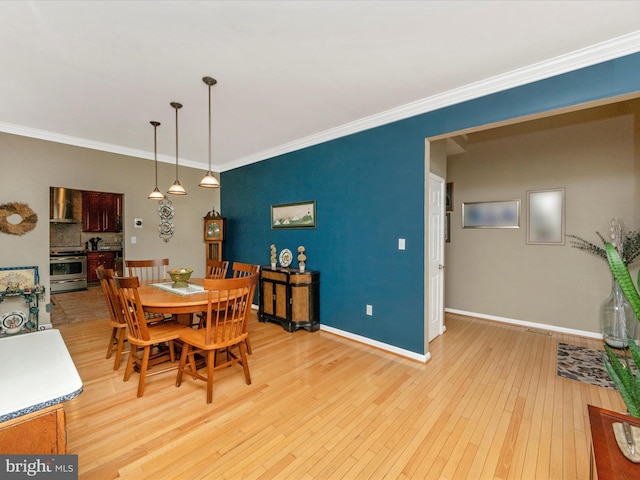 dining room featuring crown molding and light hardwood / wood-style floors