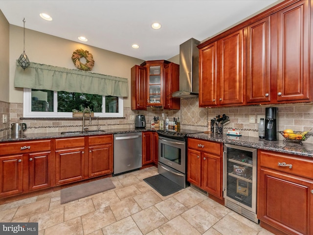 kitchen featuring wall chimney exhaust hood, dark stone countertops, wine cooler, sink, and stainless steel appliances