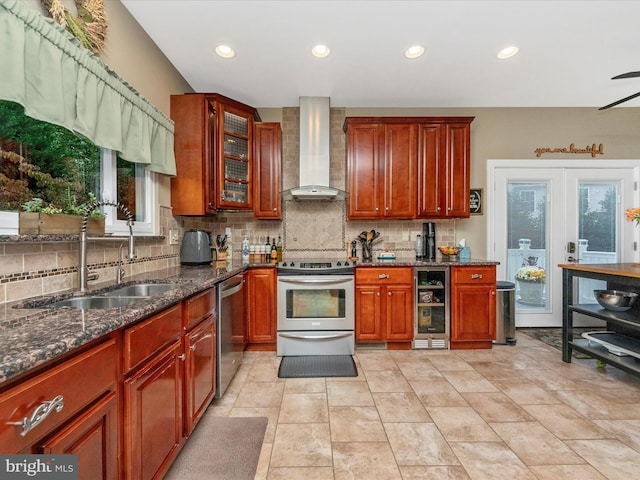 kitchen featuring wall chimney exhaust hood, stainless steel appliances, wine cooler, sink, and decorative backsplash