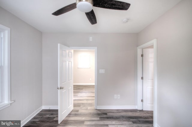 interior space with dark hardwood / wood-style floors, multiple windows, and ceiling fan