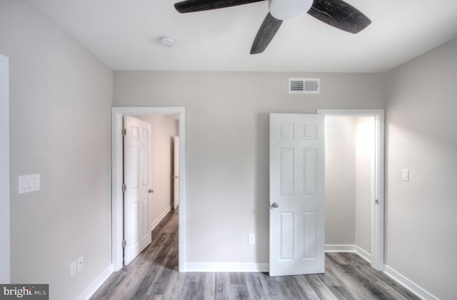 unfurnished bedroom with ceiling fan and wood-type flooring