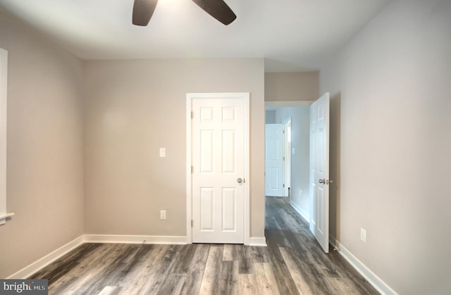 empty room with ceiling fan and dark hardwood / wood-style flooring