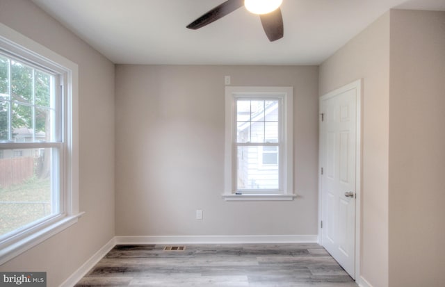 empty room featuring ceiling fan, light hardwood / wood-style floors, and a healthy amount of sunlight