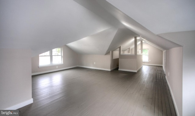 bonus room with vaulted ceiling and dark hardwood / wood-style flooring