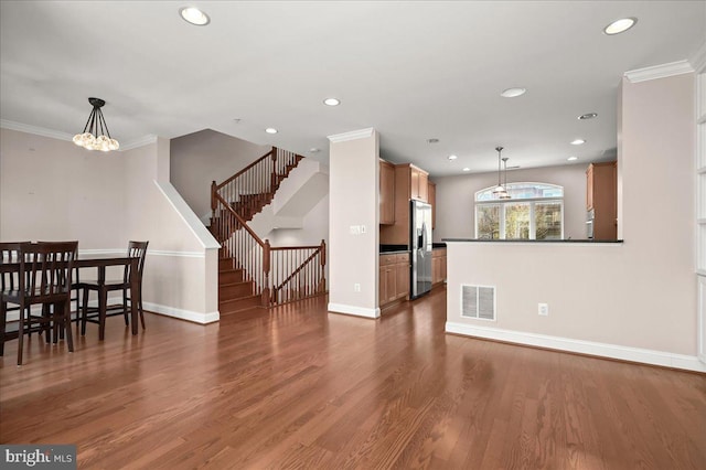 living room featuring an inviting chandelier, crown molding, and dark hardwood / wood-style flooring