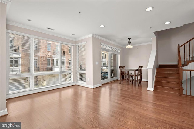 unfurnished living room with a notable chandelier, crown molding, and wood-type flooring