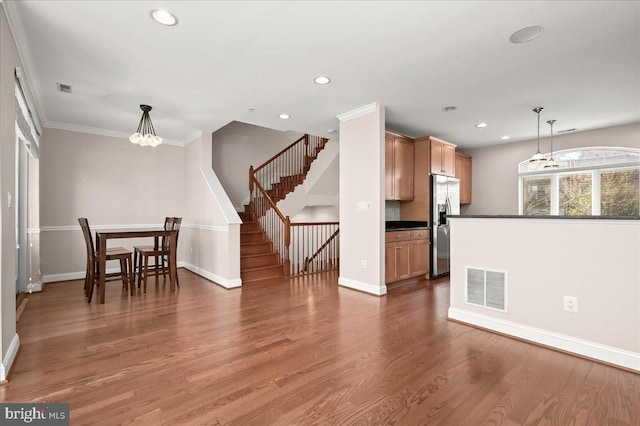 kitchen featuring an inviting chandelier, dark hardwood / wood-style flooring, hanging light fixtures, stainless steel refrigerator with ice dispenser, and ornamental molding