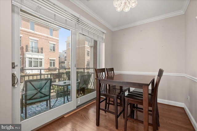 dining space featuring crown molding, an inviting chandelier, and dark hardwood / wood-style floors