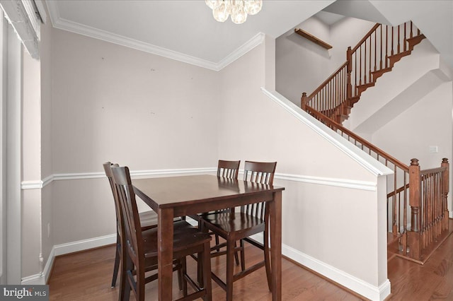 dining room featuring crown molding, hardwood / wood-style floors, and a chandelier