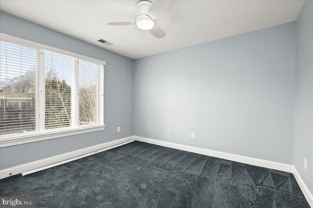 empty room featuring dark carpet and ceiling fan