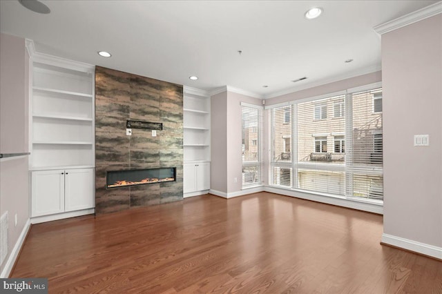 unfurnished living room with a fireplace, ornamental molding, and hardwood / wood-style floors