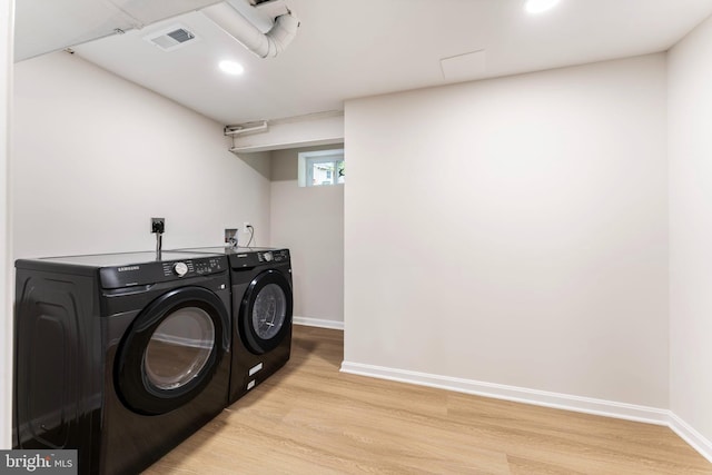 laundry area featuring washer and clothes dryer and light wood-type flooring