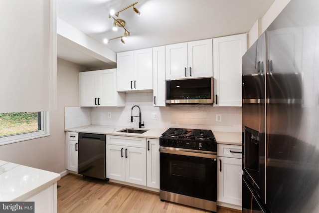 kitchen with white cabinetry, appliances with stainless steel finishes, sink, and light wood-type flooring