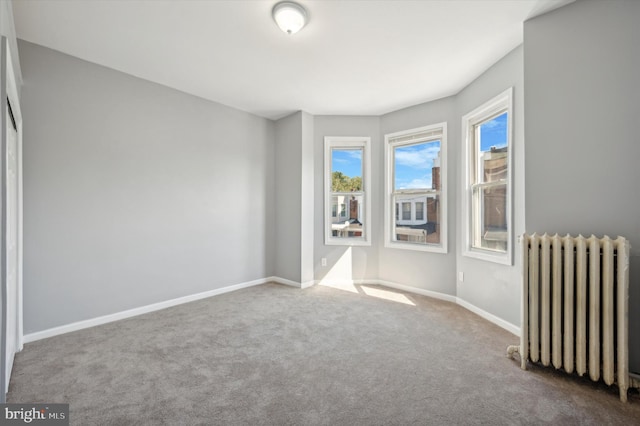 empty room with carpet floors and radiator