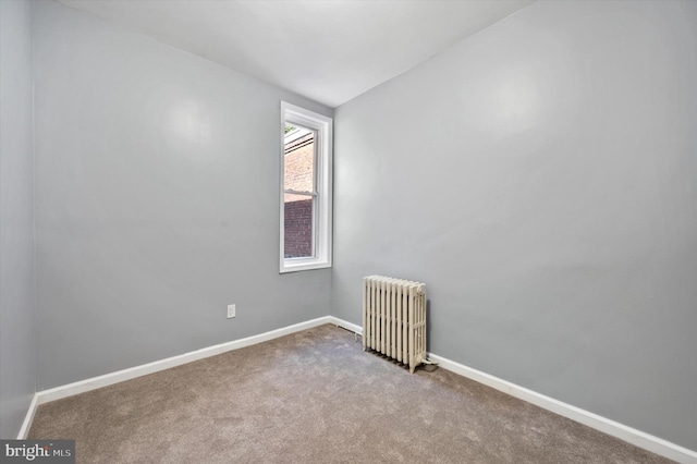 unfurnished room featuring radiator and carpet flooring