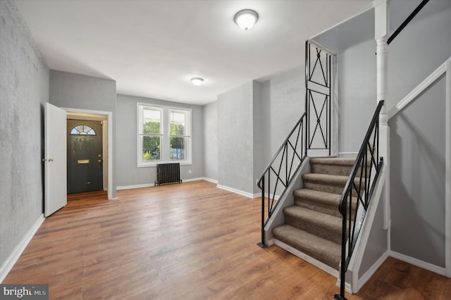 entrance foyer featuring radiator heating unit and wood-type flooring