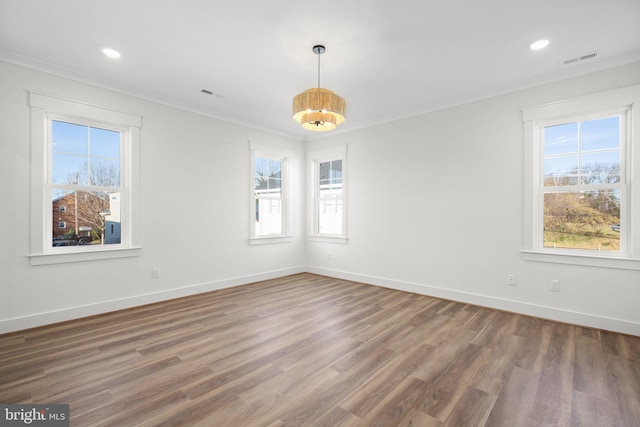 unfurnished room with a healthy amount of sunlight, dark hardwood / wood-style flooring, and ornamental molding