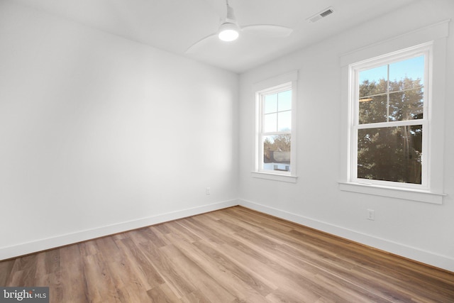 unfurnished room featuring a wealth of natural light, ceiling fan, and light hardwood / wood-style floors