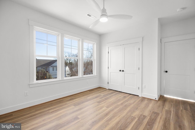 unfurnished bedroom featuring ceiling fan, a closet, and hardwood / wood-style flooring