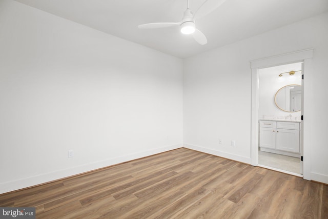 unfurnished bedroom featuring connected bathroom, ceiling fan, sink, and light hardwood / wood-style floors