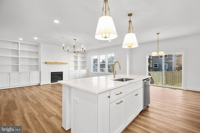 kitchen with decorative light fixtures, a kitchen island with sink, plenty of natural light, and sink