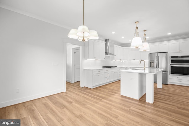 kitchen featuring white cabinetry, wall chimney range hood, appliances with stainless steel finishes, and light hardwood / wood-style flooring