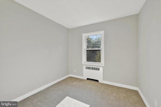 carpeted spare room with radiator heating unit