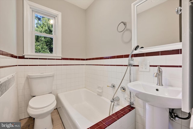 bathroom featuring a bath, toilet, tile patterned floors, and tile walls