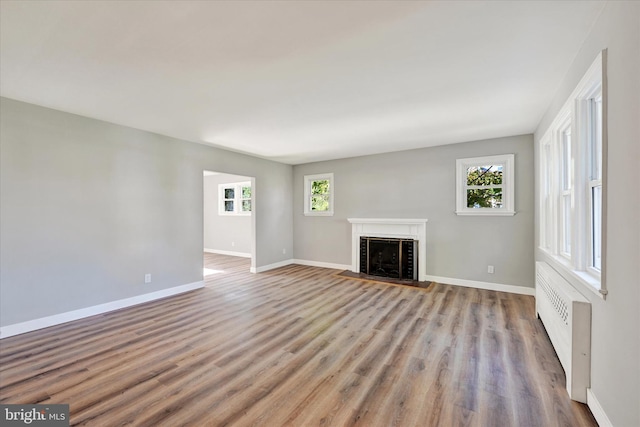 unfurnished living room featuring light hardwood / wood-style floors and radiator