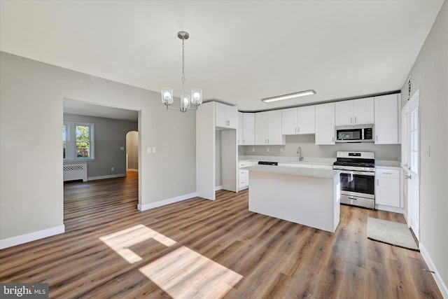 kitchen featuring white cabinetry, appliances with stainless steel finishes, wood-type flooring, and sink