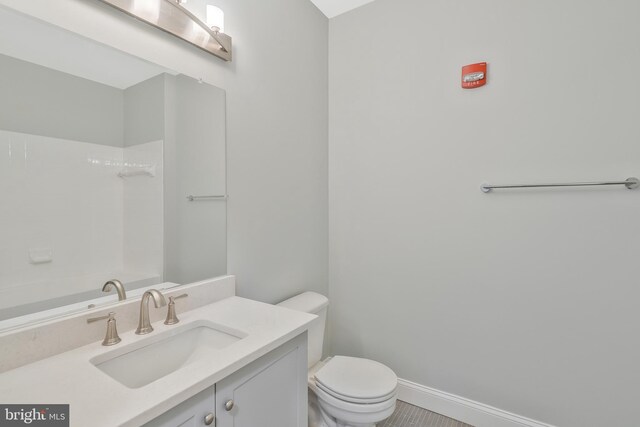 bathroom featuring toilet, vanity, a shower, and tile patterned flooring