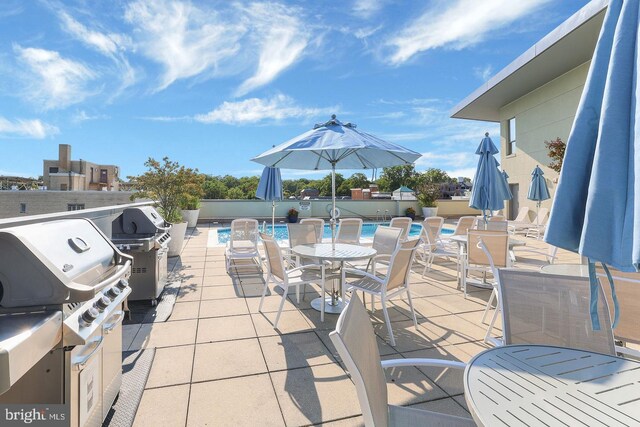 view of patio / terrace featuring a community pool and grilling area