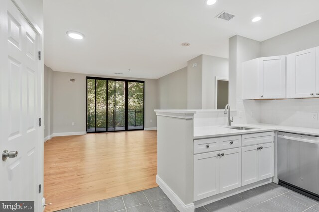 kitchen featuring dishwasher, light hardwood / wood-style flooring, kitchen peninsula, sink, and white cabinetry