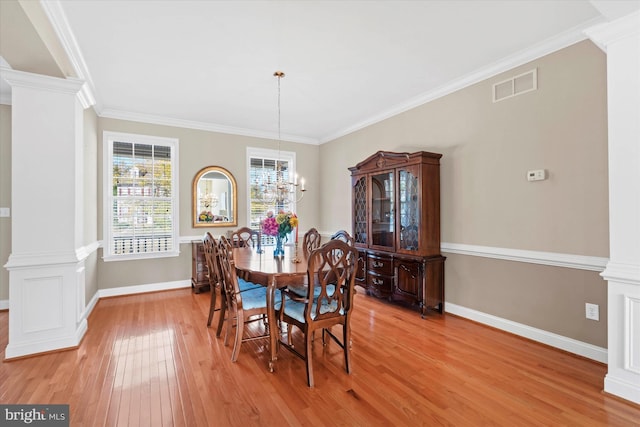 dining area featuring decorative columns, crown molding, and hardwood / wood-style floors