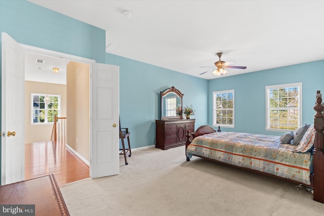 carpeted bedroom with ceiling fan and multiple windows